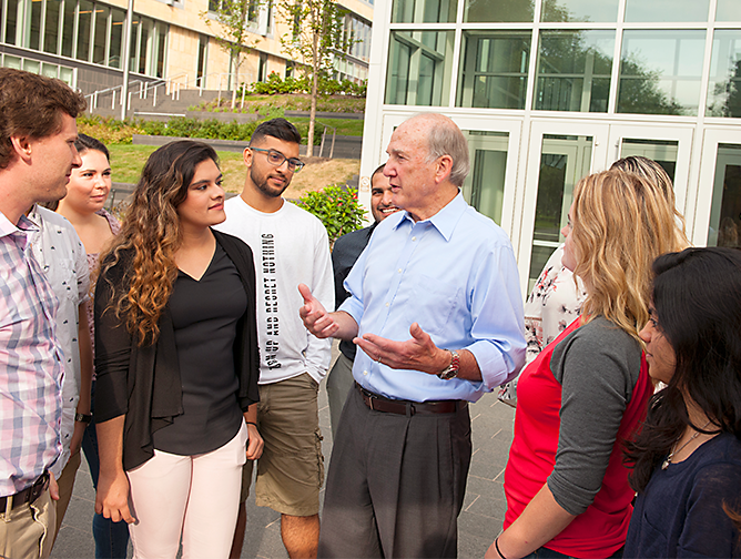 President Barchi talking to a group of students outside the new Academic building on the College Avenue Campus in New Brunswick